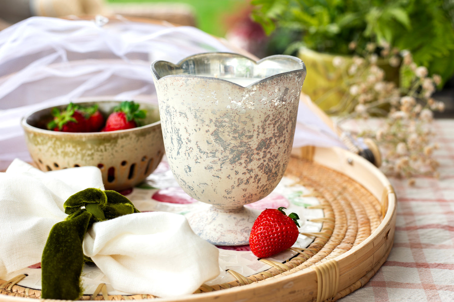 Scent of Home Luxe Collection candle — hand-poured soy candle in a luxury mercury glass vessel, surrounded by fresh strawberries and soft textures