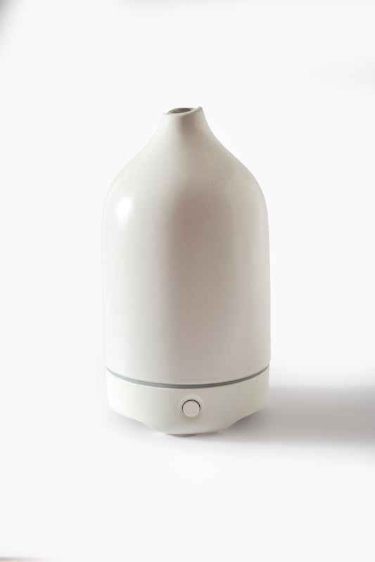 White ceramic essential oil diffuser on a white background — modern minimalist design for clean home fragrance.