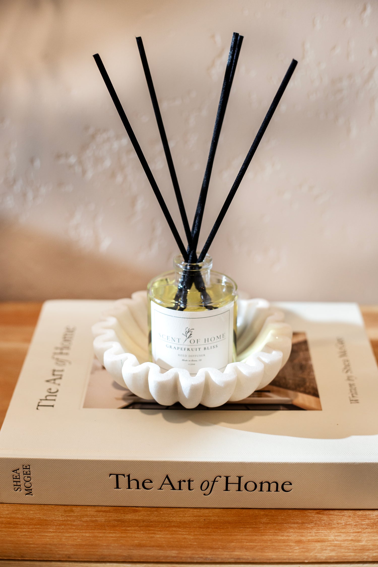 Scent of Home Grapefruit Bliss reed diffuser displayed on a book titled ‘The Art of Home’ — showcasing the clean, elegant design and quality of wholesale offerings.