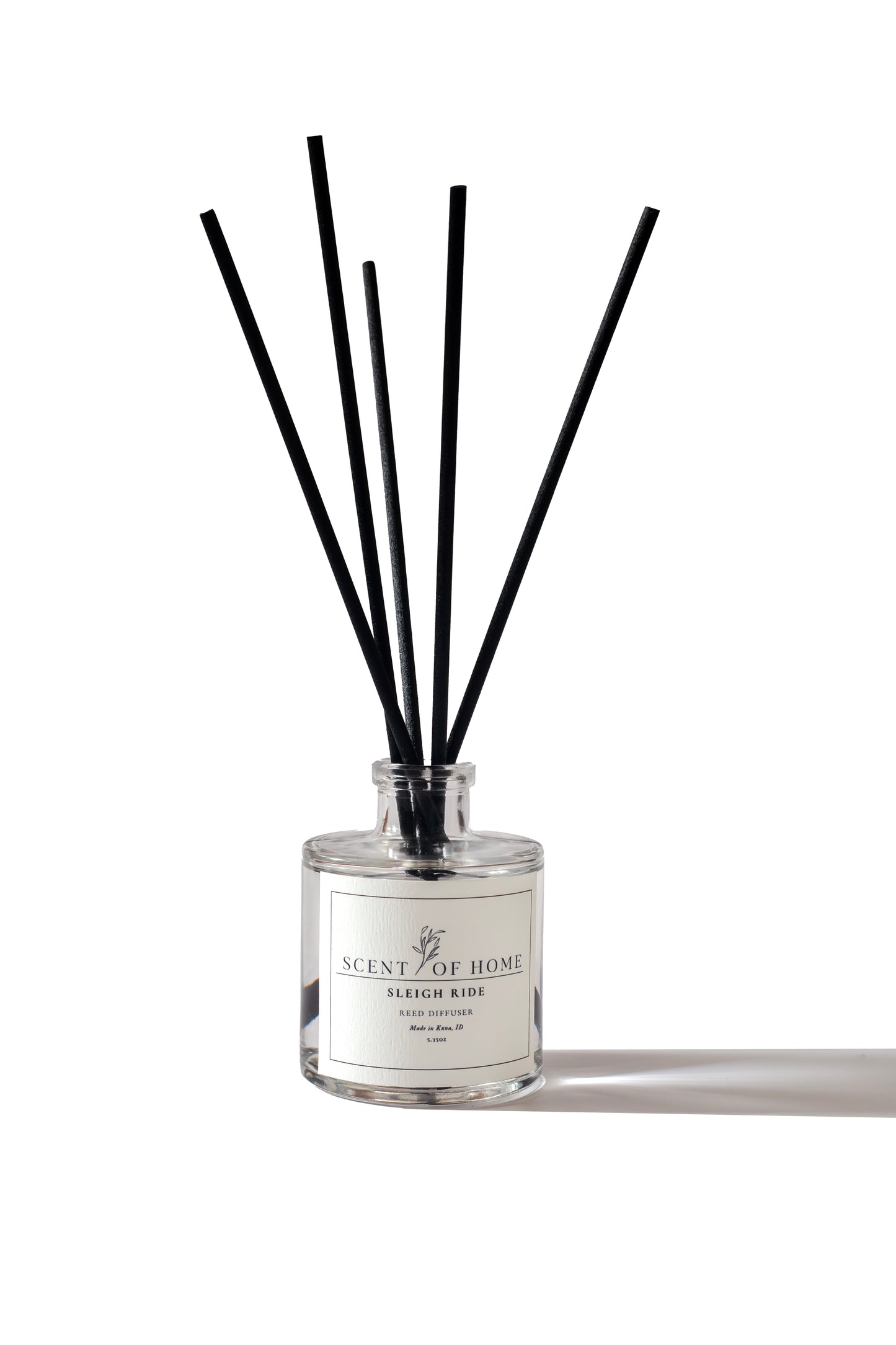 Scent of Home Sleigh Ride reed diffuser bottle with black diffuser sticks against a clean white background.