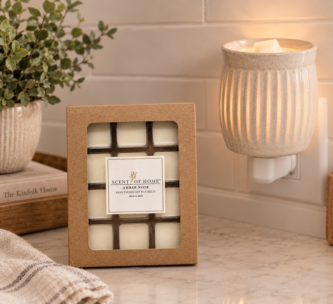 Scent of Home Amber Noir soy wax melts next to a ceramic plug-in wax warmer on a kitchen counter
