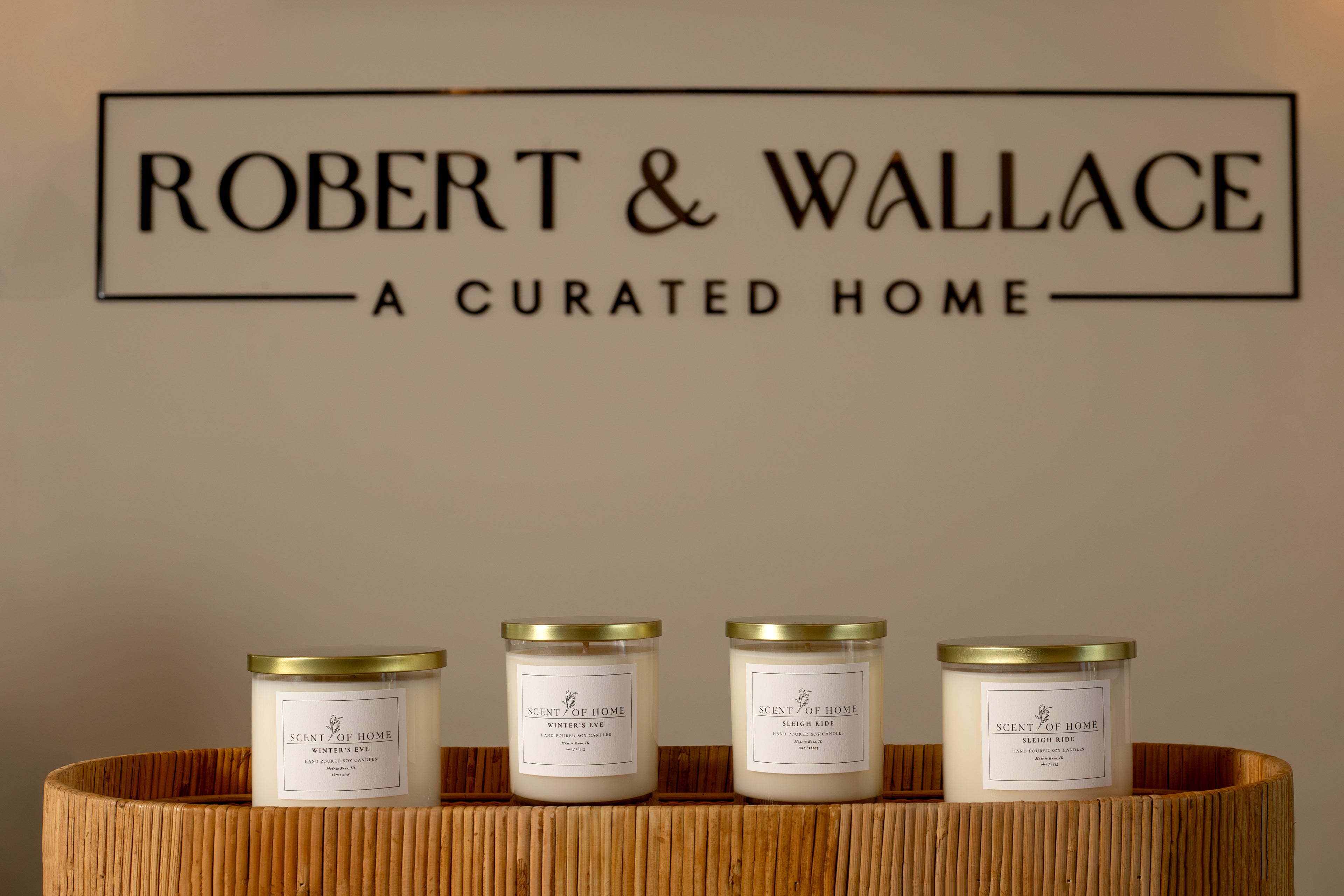 Scent of Home Winter’s Eve and Sleigh Ride candles displayed on a wooden table inside Robert & Wallace, A Curated Home — showcasing an elegant in-store presentation of the collection.