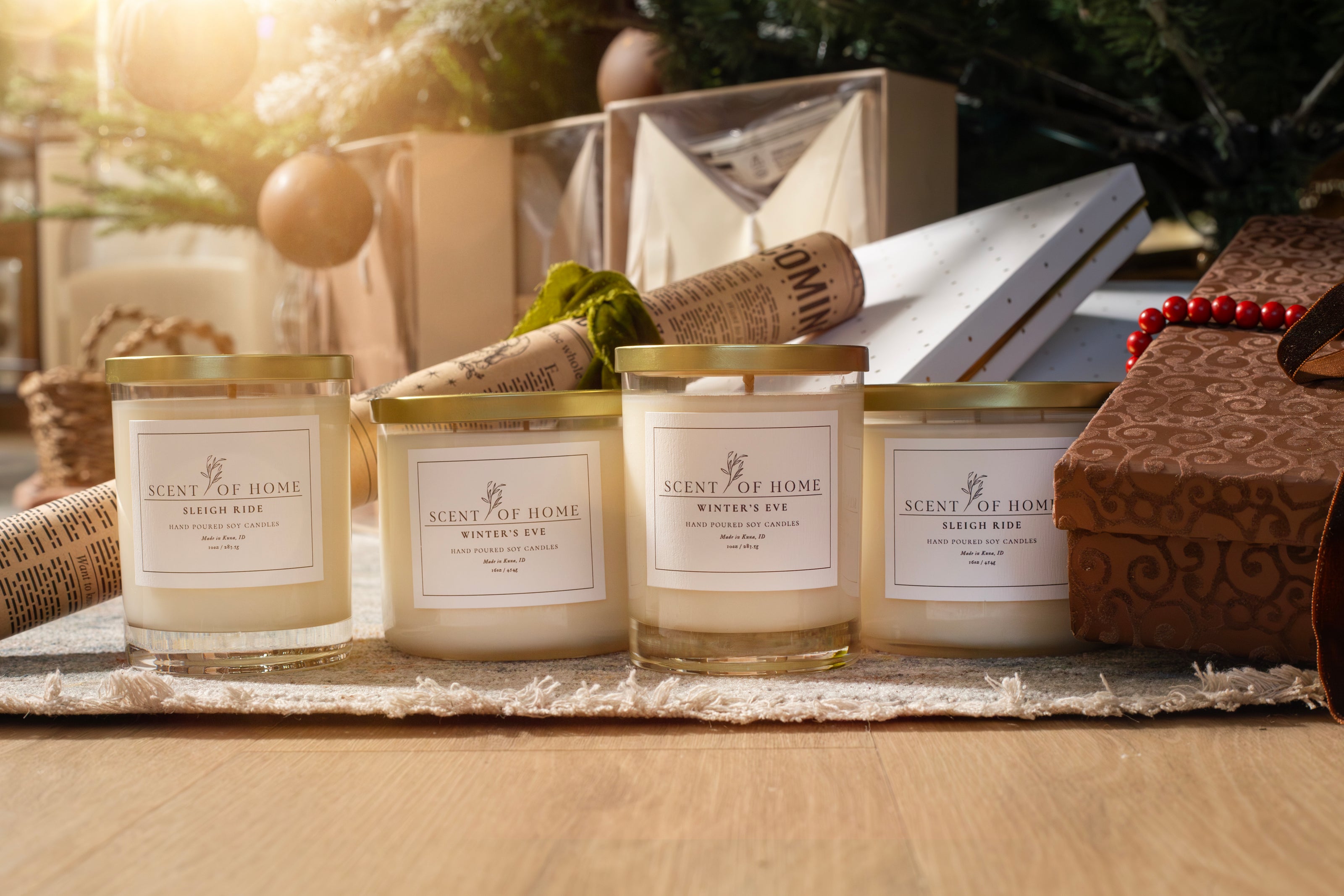 Scent of Home Winter’s Eve and Sleigh Ride candles arranged together in front of wrapped gifts and holiday décor, capturing a cozy and elegant Christmas atmosphere with warm morning light.