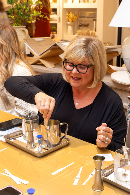 Participant at a Scent of Home candle pouring workshop — hands-on candle making event where guests craft their own soy candles.