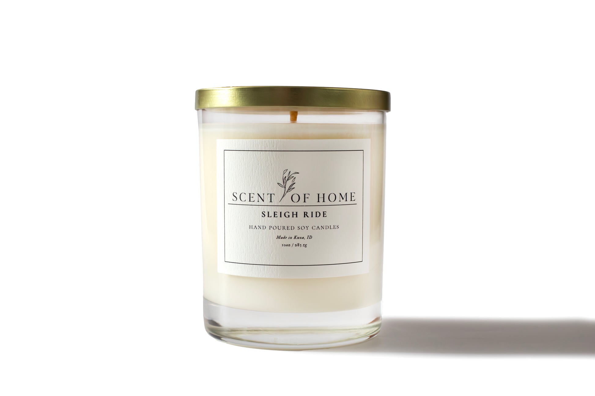 Scent of Home Sleigh Ride 10 oz hand-poured soy candle with gold lid, displayed on a white background with soft lighting highlighting its minimalist label and clean design.